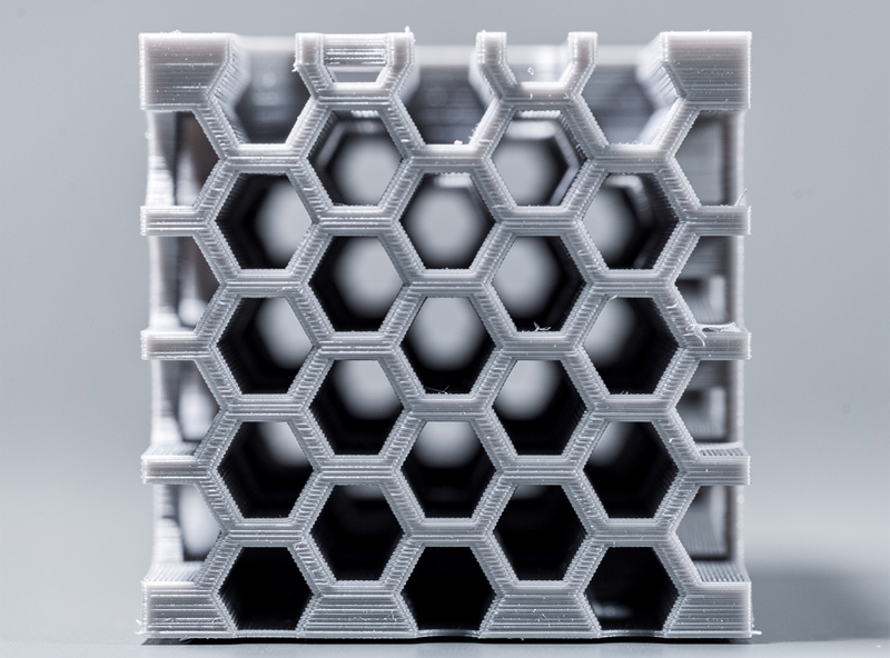 Honeycomb hexagonal infill pattern visible inside a 3D printed cube cross-section