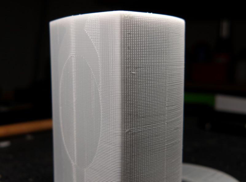 A 3D printed cylindrical part showing ghosting and ringing echo patterns on its vertical walls