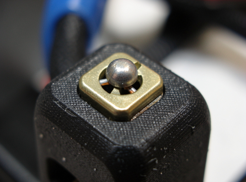Close-up of a 3D printer hotend showing the thermistor and heater cartridge secured in the heater block