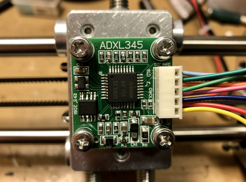 An ADXL345 accelerometer module bolted to a 3D printer toolhead with jumper wires