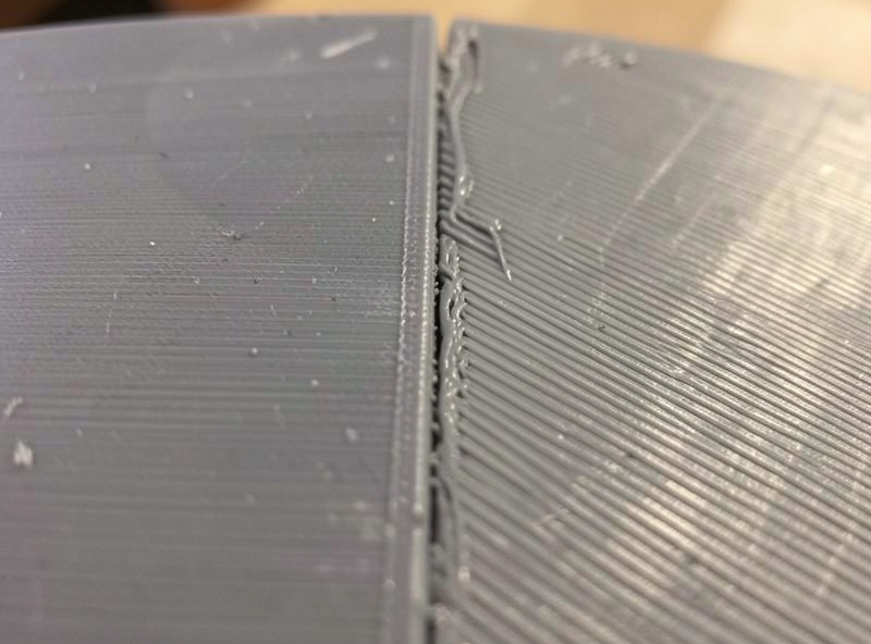 Macro of a 3D print partway through filler primer, one section sanded flat and the other still showing faint layer line valleys