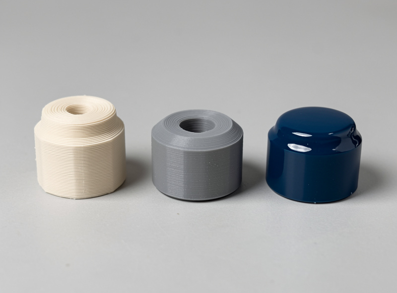 Three identical 3D printed parts showing the finishing progression from raw layer lines to primed to painted and clear-coated