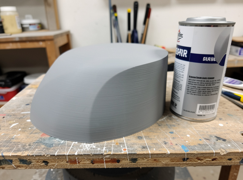 A 3D printed part coated in grey filler primer with a smooth uniform surface