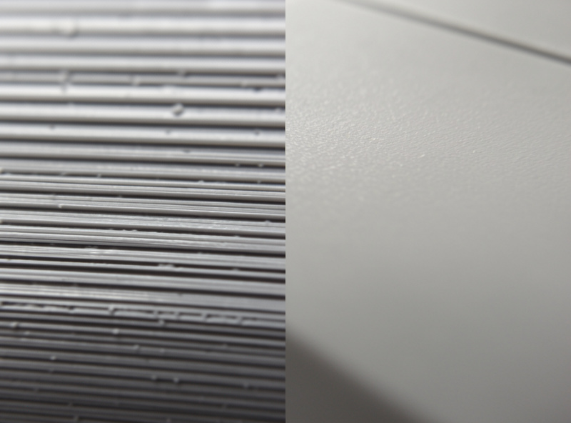 Macro comparison of a 3D printed surface with layer lines on one half and sanded smooth on the other