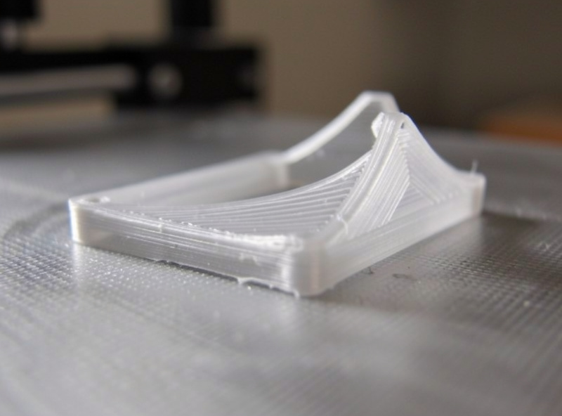 A polycarbonate print warping at the corners lifting off the print bed