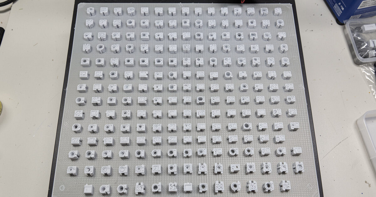 A 3D printer bed fully plated with many identical functional parts in a batch run